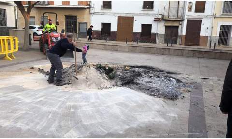 Un operari arreplega les cendres de la primera falla.