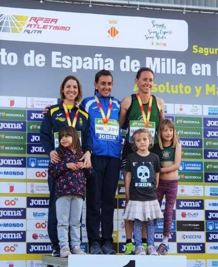 Marian Ruiz, a la izquierda, segunda en el podio F35 de la milla.