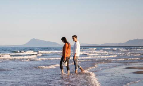 Una pareja pasea por la playa de Gandia.