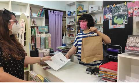 Una clienta compra un libro con cheques en un comercio de Gandia. / Foto: J.C.