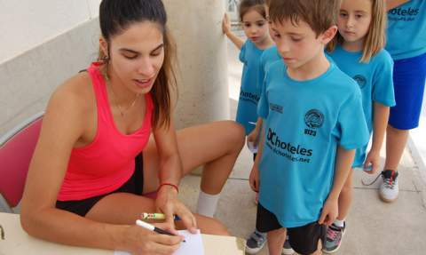 Paola firma un aut&oacute;grafo.